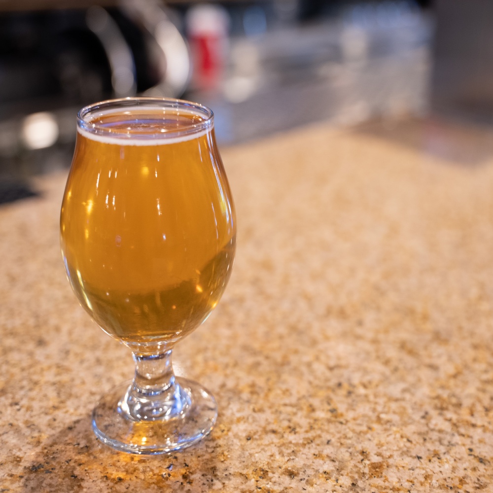 A glass of beer on a counter.